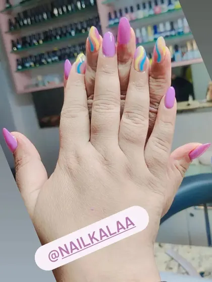 A playful design with solid pink nails and accent nails featuring colorful pastel swirls.