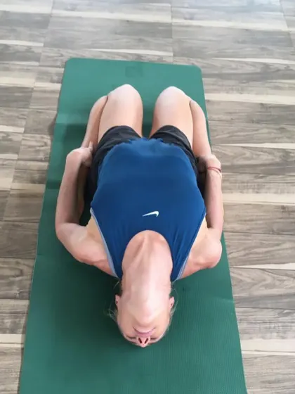 A guest practices Matsyasana (Fish Pose), a heart-opening backbend. This pose helps to improve posture, stretch the chest and neck, and relieve tension.