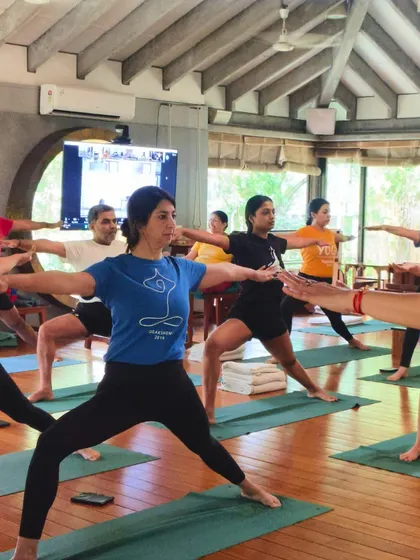 Strength in unity, focus in flow. A class practices Virabhadrasana II (Warrior II Pose), demonstrating how we grow stronger not just individually, but as a community.