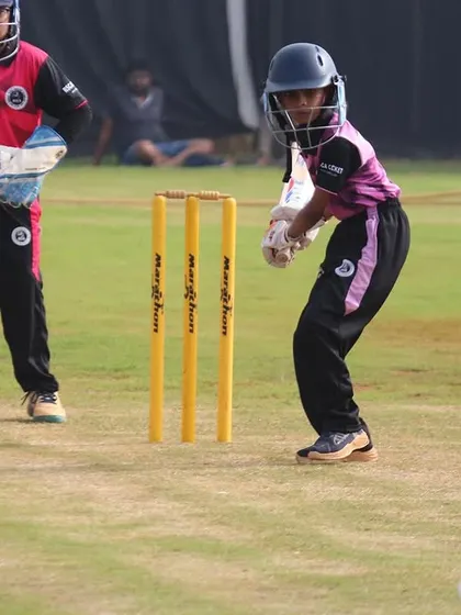 A young batter watches the ball closely onto the bat, a fundamental skill for good timing and shot selection.