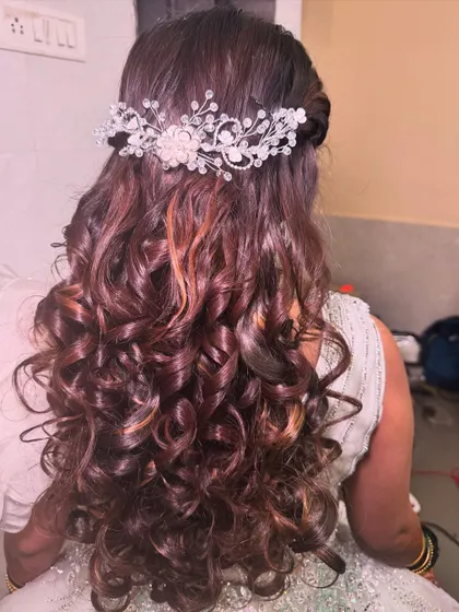 A beautiful hairstyle with soft curls and a sparkling hair accessory. This is a perfect choice for a reception or engagement look.