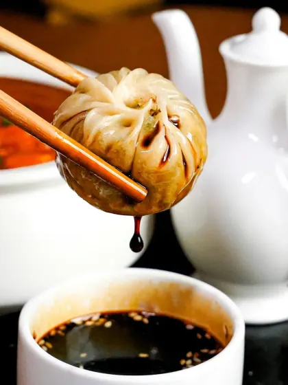 Sometimes, the most powerful stories are in the smallest details. We captured this precise moment of a dim sum being dipped in soy sauce, focusing on the drip to evoke an immediate sense of craving. This is our approach to minimalist, moody food photography, where the dish itself holds all the drama.