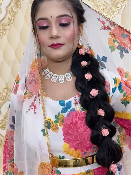 A beautiful floral braid hairstyle paired with pink makeup, perfect for a sangeet or mehendi party.