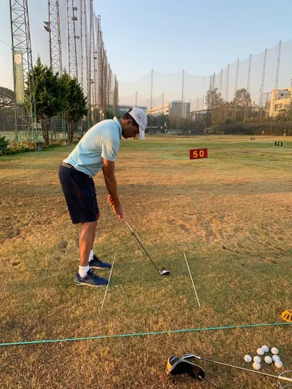 A student working on his swing at the driving range during a beautiful sunset. Lessons are available at various times to fit your schedule.