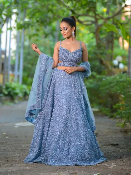 A stunning dusty blue lehenga, fully adorned with intricate sequin work in a swirling rose pattern. This modern outfit is a fantastic choice for a sangeet night or a glamorous reception party.