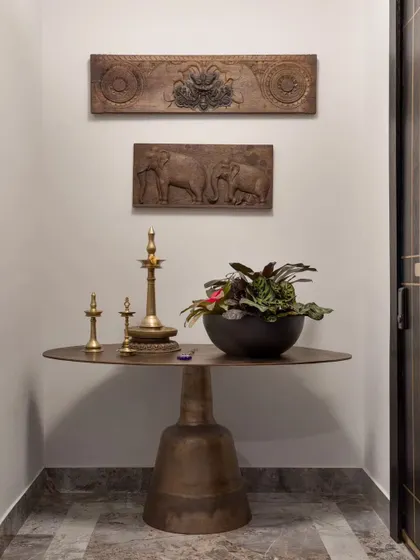 The entrance nook at our Bengaluru project. We paired traditional carved wooden panels and brass lamps with a modern, sculptural table to reflect our client's heritage and contemporary taste.