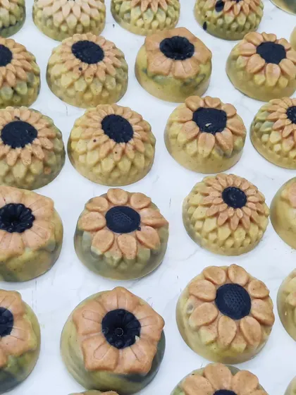 A collection of sunflower-shaped Ubtan cold process soaps.