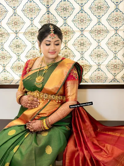 A serene portrait of a mom-to-be. The elegance of the green and red silk saree is matched with soft, glowing makeup for her seemantham ceremony.