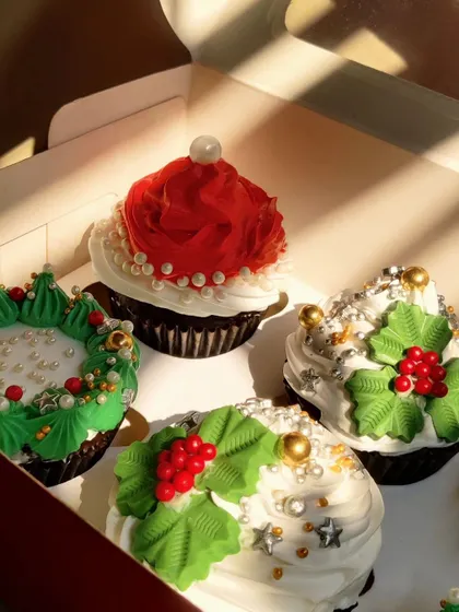 Golden hour hitting these Christmas cupcakes just right. You can see the detail on the buttercream holly leaves and the delicate pearl sprinkles that make each cupcake a tiny work of art.
