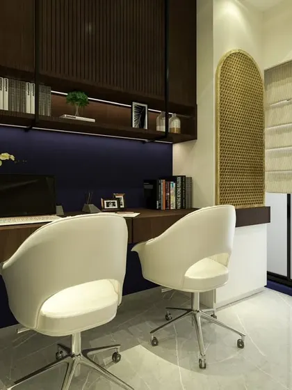 This before-and-after shows the transformation of a cluttered corner into a sophisticated dual-person workspace. The deep blue wall, warm wood tones, and integrated Mandir create a space that is both productive and peaceful.