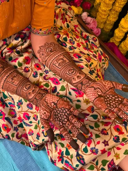 A top-down view of Sahana's complete bridal mehendi, showcasing the intricate work on her hands and arms.