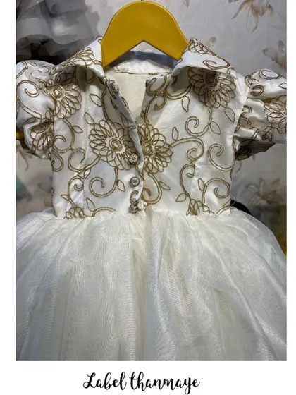 A close-up of the golden embroidery on the shirt-style bodice of this frock.