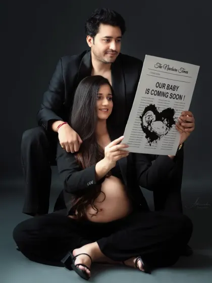A creative and modern announcement. This couple used a "Newborn Times" prop to share their exciting news in a unique and memorable way.