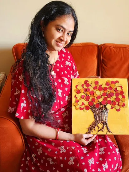 A smiling client with her personalized Vaastu art. The colors chosen for this piece are meant to invoke joy and active financial growth.