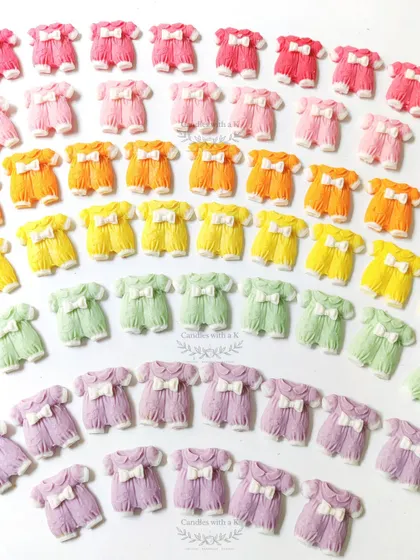 Colorful baby onesie shaped wax sachets, which also function as fridge magnets, made for a baby shower.