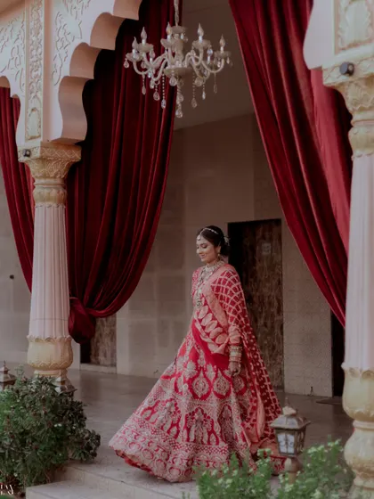 A beautiful shot of the bride twirling in her red wedding lehenga.