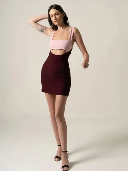 A shot for a fashion brand's catalogue, featuring a color-blocked mini dress. The pose is simple yet chic, designed to showcase the unique design of the garment.