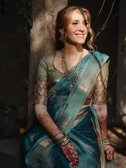 The bride's radiant smile is captured in this sun-kissed shot, with her stained henna adding to her beauty.