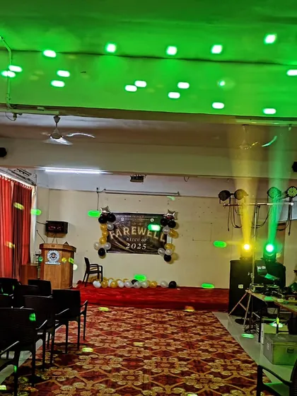 A farewell party setup showing my DJ station, speakers, and party lights. The green laser lights create a fun, energetic atmosphere on the dance floor.