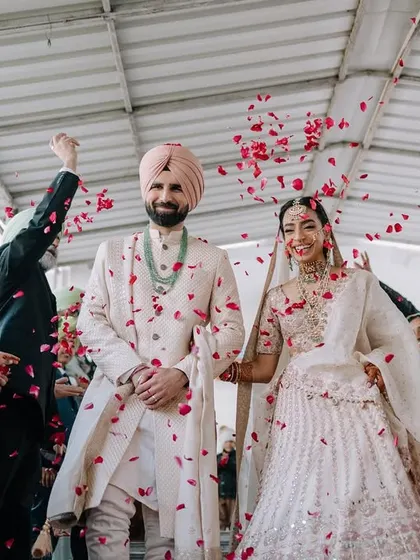Walking out of the Gurudwara as husband and wife, showered with petals and blessings. This is a classic Punjabi wedding moment, filled with happiness and tradition.