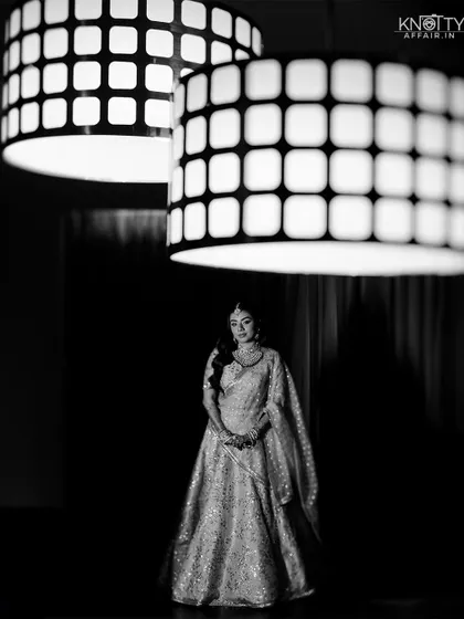 A striking black and white bridal portrait using modern light fixtures as a framing element. This showcases our creative use of the environment.