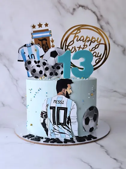 Messi! A cake for a fan of the Argentinian football legend. This cake features his jersey, the AFA logo, and edible soccer balls.