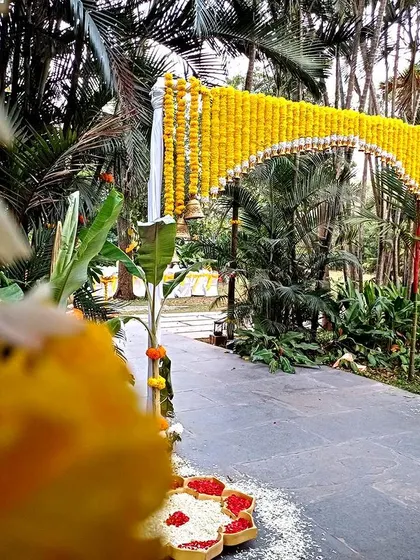 A traditional entrance arch made of marigolds, leading into a lush garden venue.