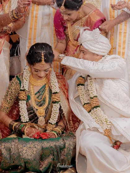 The couple participates in a traditional ritual, surrounded by family. This high-angle shot provides a unique perspective on the ceremony's beautiful proceedings.