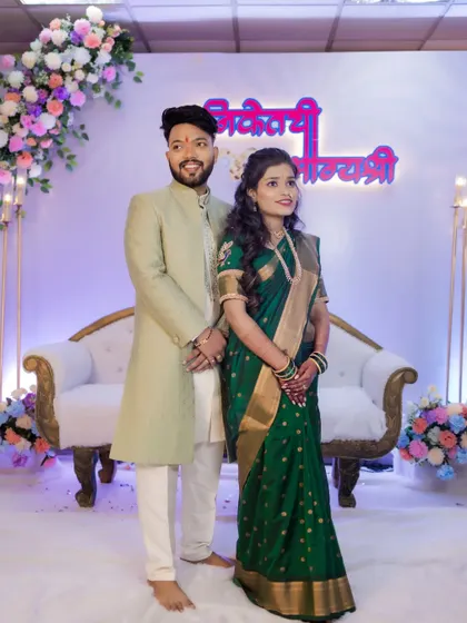 A classic stage portrait of the newly engaged couple, looking elegant against the beautifully decorated backdrop of their ring ceremony.