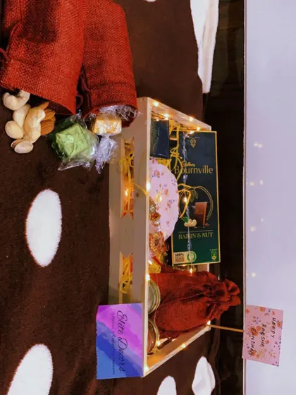 A slightly different arrangement of the Rakhi hamper, showing the contents from a new perspective. The fairy lights add a magical touch to the entire gift.