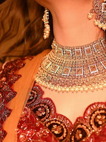 Another angle of the beautiful bridal necklace, capturing how it sits perfectly and complements the rich fabric of the lehenga.