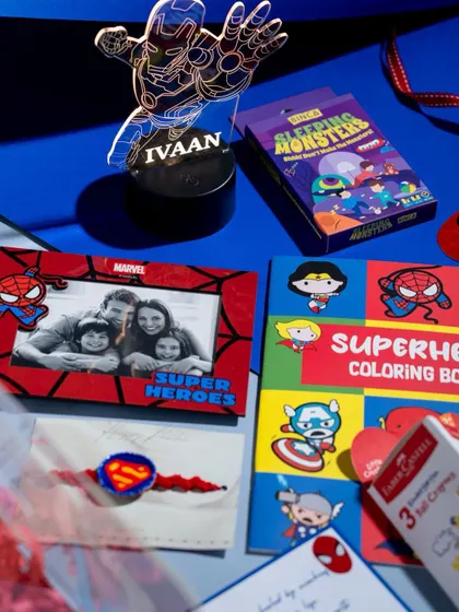 A closer look at the personalized items in our Superhero hamper, including a custom Iron Man LED lamp with the child's name, a Spiderman photo frame, and a Superman Rakhi.