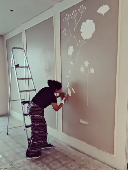 A candid shot of me working on a large, three-panel mural in a Mumbai apartment. Creating large-scale art requires focus, patience, and a steady hand, especially when working on a ladder.