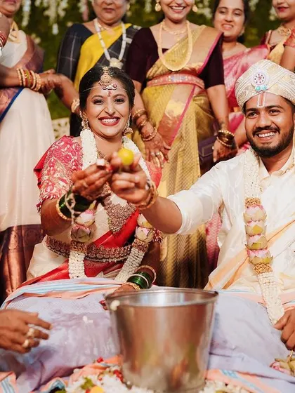 The fun and games continue with the Aeki-Beki ritual, where the couple searches for a ring in a pot of colored water, surrounded by cheering family.