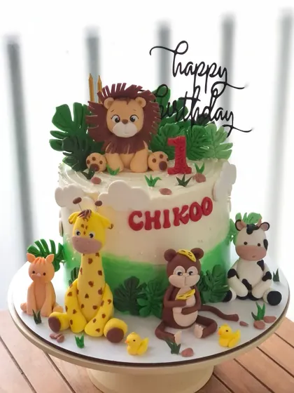 A fun safari cake for a first birthday, with a whole crew of cute, handcrafted animals ready to party.