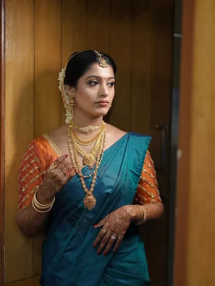 A pensive moment before the ceremony. The makeup is subtle yet defining, focusing on creating a flawless canvas and enhancing the eyes.