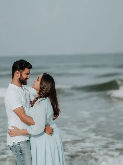 A quiet moment of connection with the ocean waves in the background, perfect for a serene and romantic couple portrait.
