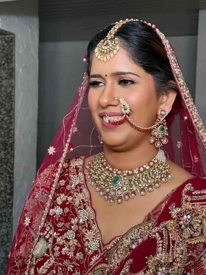 A candid, happy moment. This bride's natural beauty is enhanced with a soft glam look, perfect for her maroon lehenga.