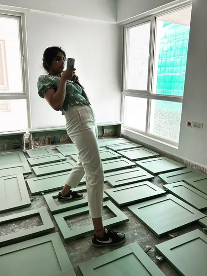 Our lead architect, Anjali, finding her balance among freshly painted cabinet shutters. This is a glimpse into the hands-on, and sometimes playful, nature of our site work.