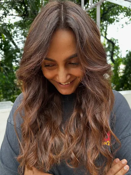 A happy, candid shot of the client enjoying her fresh hair, ready for her work trip.