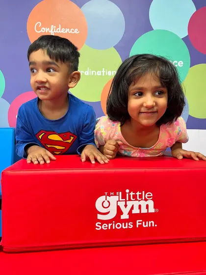 Two friends peeking over a block, ready for their next adventure. Our gym is a place where social skills blossom, and children learn to play and explore together.