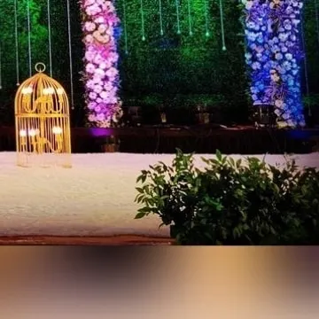 Another view of the decorative birdcage prop, showing how it complements the floral columns and green backdrop. I carefully select props that enhance the theme, whether it's modern, rustic, or traditional.