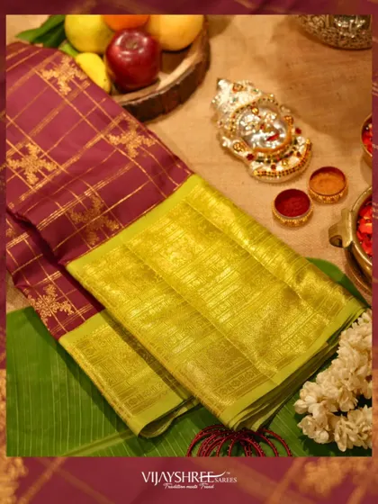 A vintage Kanjivaram in wine and lime green, a classic festive combination, laid out with puja essentials.