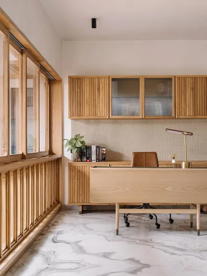 This home office in Cocoon House is a study in texture and light. We used fluted wood for the cabinetry and a pegboard-style backsplash, creating a tactile and organized workspace. The large window with wooden mullions allows natural light to flood the room, making it a calm and inspiring place to work.