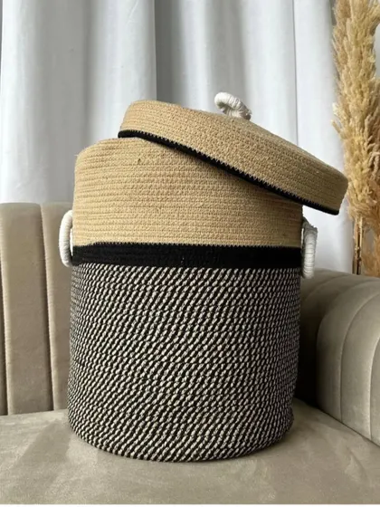 This dual-toned black and beige rope basket is a chic and modern storage solution for any room. The lid keeps contents hidden for a clean look.