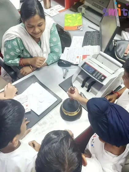 Children get a close-up look at a postmark stamp and a currency counting machine, learning about the tools used in a post office.