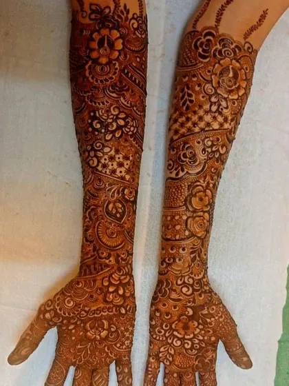 A full-arm design with a mature, dark stain. The color is consistent from the fingers all the way to the elbows, creating a flawless and traditional bridal look.