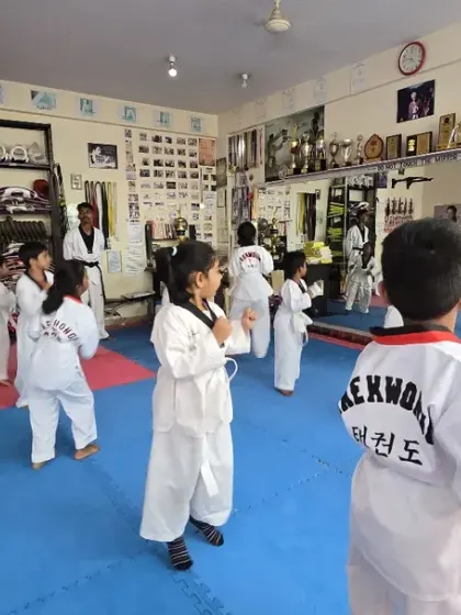 A view from the back, showing the "TAEKWONDO" lettering on the students' doboks.