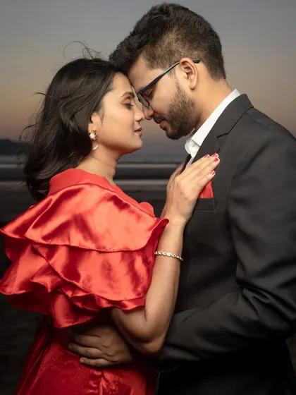 A close, intimate portrait at dusk with a dramatic red dress. The fading light provides a soft, romantic backdrop for an emotional pre-wedding photo.