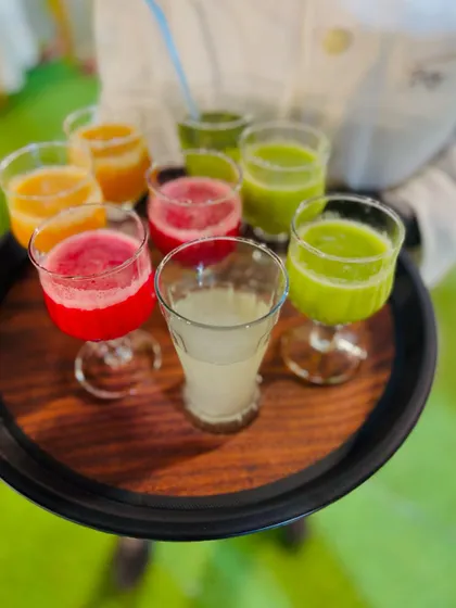 A tray holding a variety of freshly made juices, ready for service.